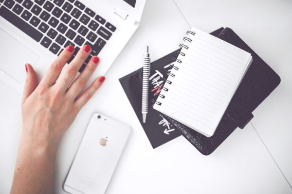 Woman's hand, notebook and computer