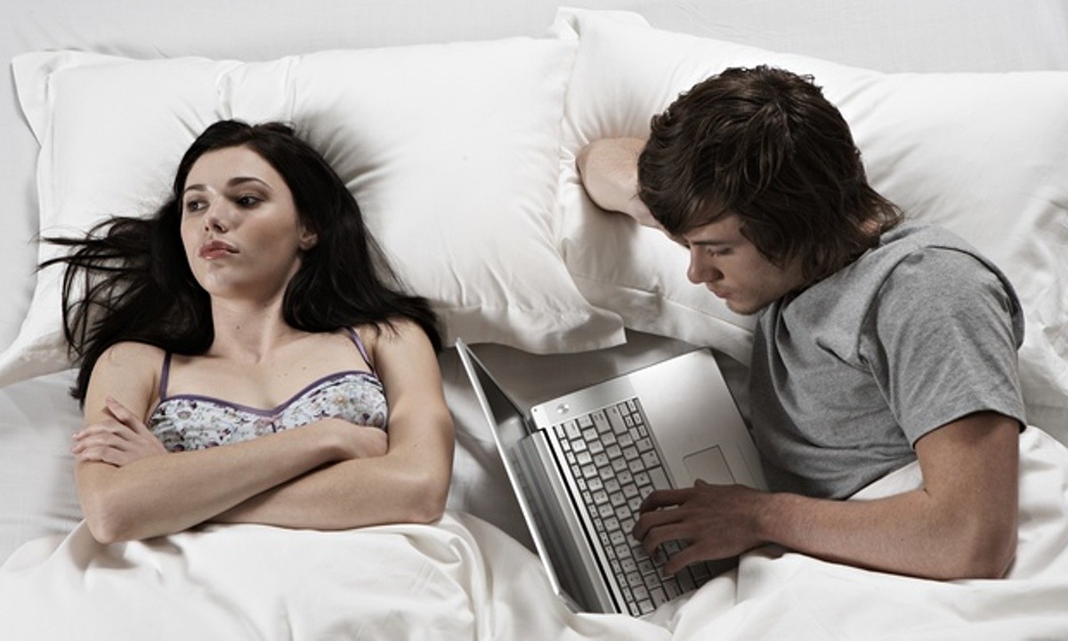 man ignoring woman in bed